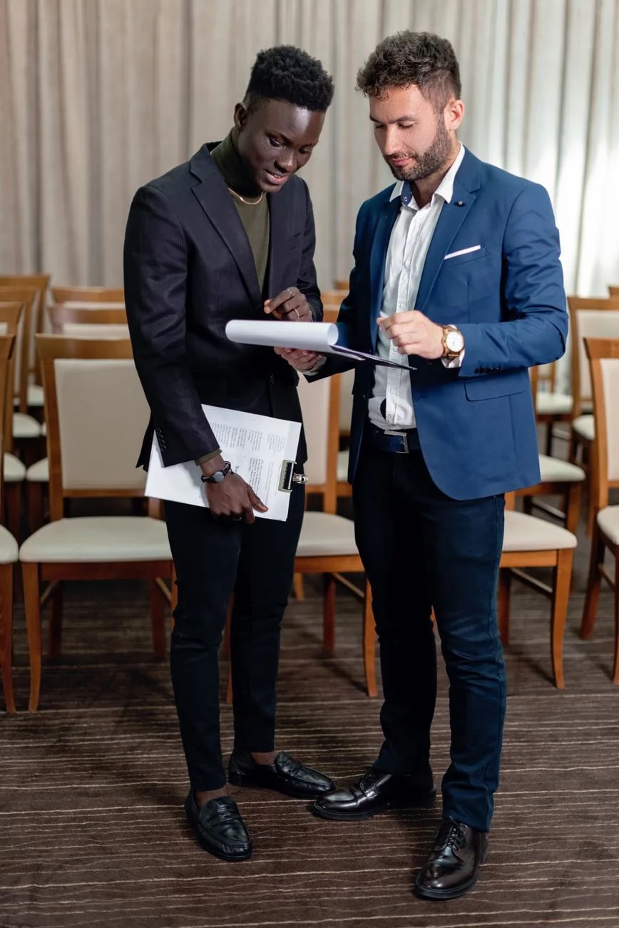 Deux professionnels relisant un document dans une salle de réception, illustration du choix d’une agence événementielle